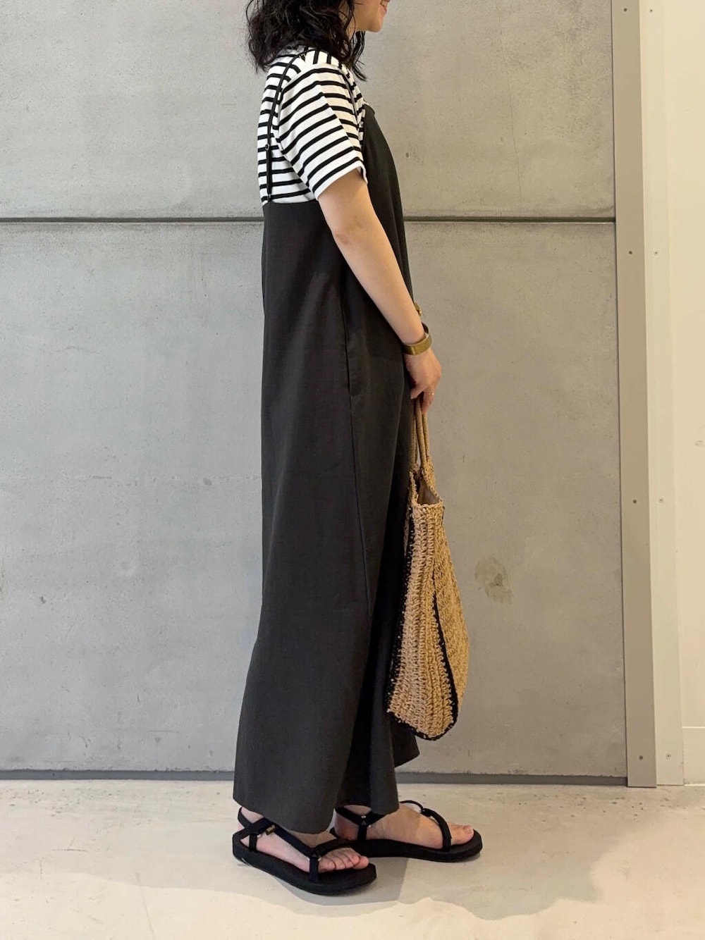 ベージュ系のトートバッグ、ホワイト系のTシャツ/カットソー、ブラック系のサンダルを着用したレディースの夏コーディネートの4枚目の写真