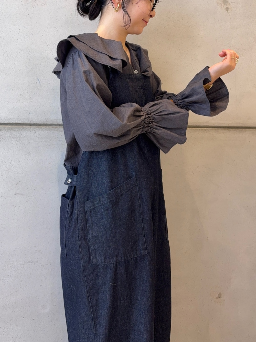 ブルー系のサロペット/オーバーオール、ブルー系のシャツ/ブラウス、ブラック系のバッグを着用したレディースの冬コーディネートの6枚目の写真