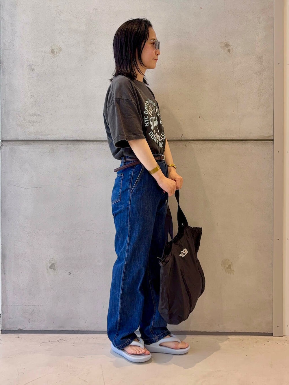 ブルー系のデニムパンツ、グレー系のTシャツ/カットソー、ブラウン系のベルトを着用したレディースの春コーディネートの3枚目の写真