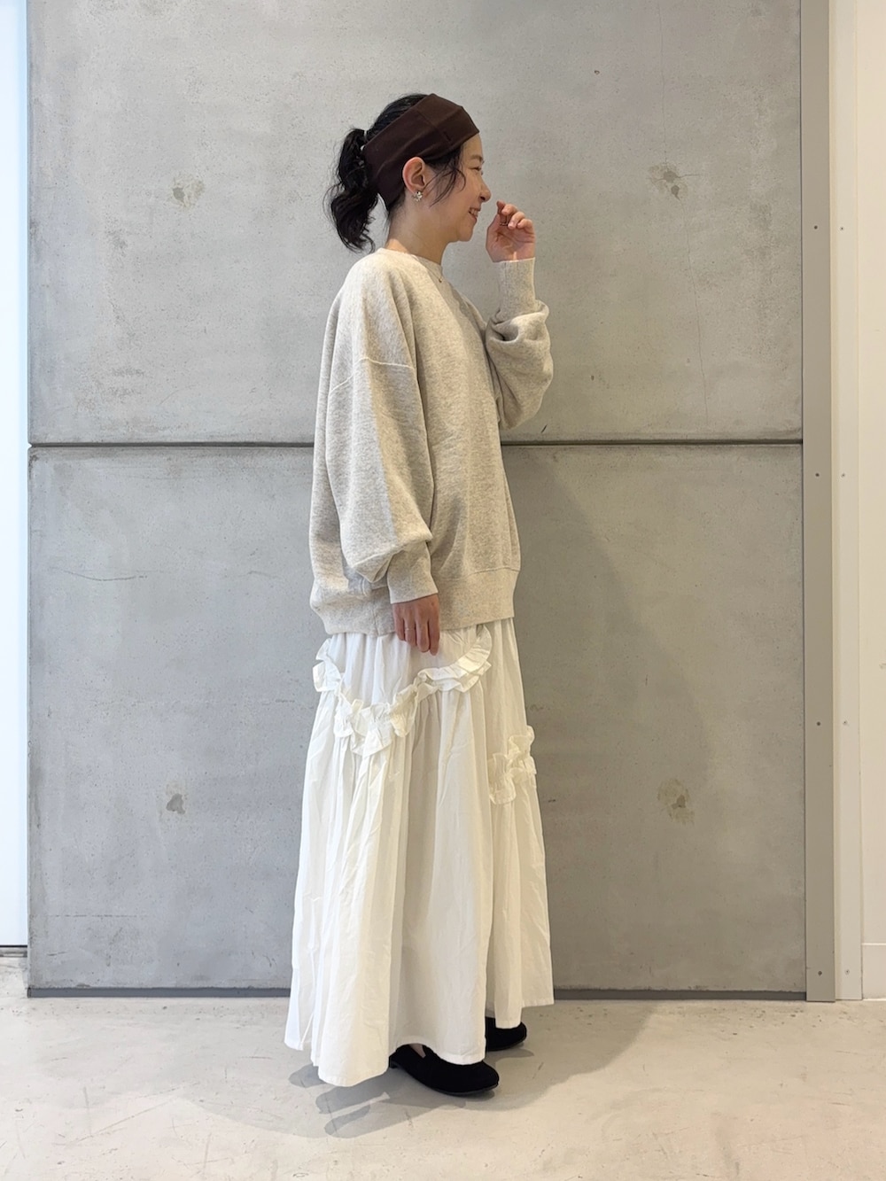 ブラック系のローファー、ホワイト系のスカート、ベージュ系のスウェットを着用したレディースの秋コーディネートの2枚目の写真