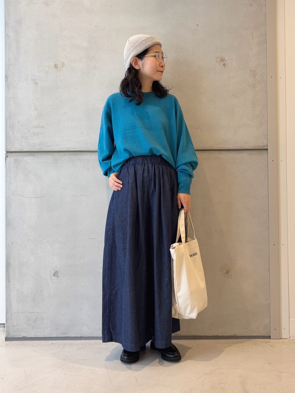 ブルー系のニット/セーター、ブラック系のローファー、ブルー系のデニムパンツを着用したレディースの秋コーディネートの2枚目の写真