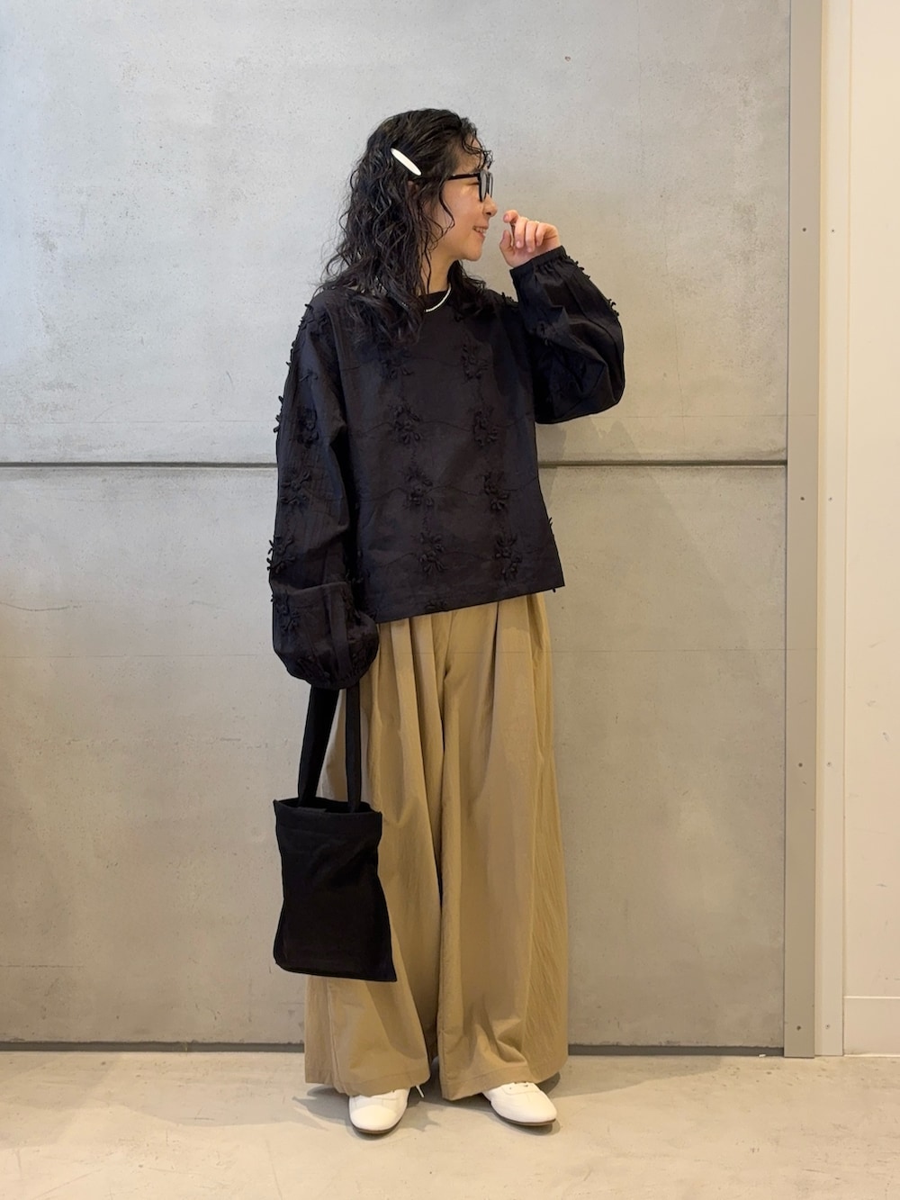 ベージュ系のその他パンツ、ブラック系のトートバッグ、ホワイト系のスニーカーを着用したレディースの春コーディネートの2枚目の写真