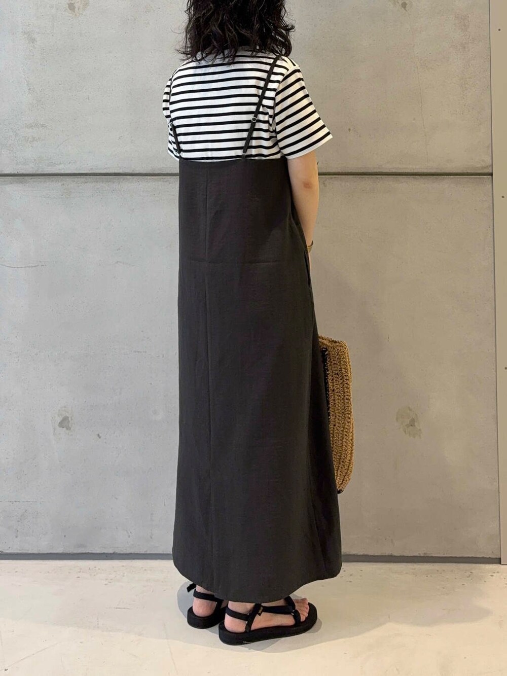 ベージュ系のトートバッグ、ホワイト系のTシャツ/カットソー、ブラック系のサンダルを着用したレディースの夏コーディネートの3枚目の写真