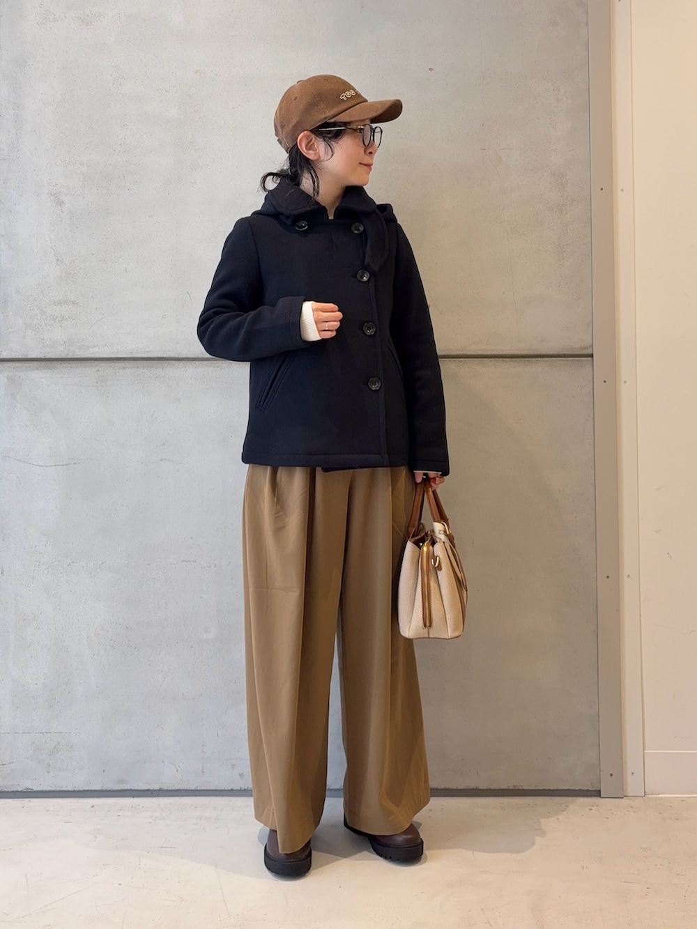 ブラウン系のブーツ、ホワイト系のニット/セーター、イエロー系のその他パンツを着用したレディースの冬コーディネートの3枚目の写真