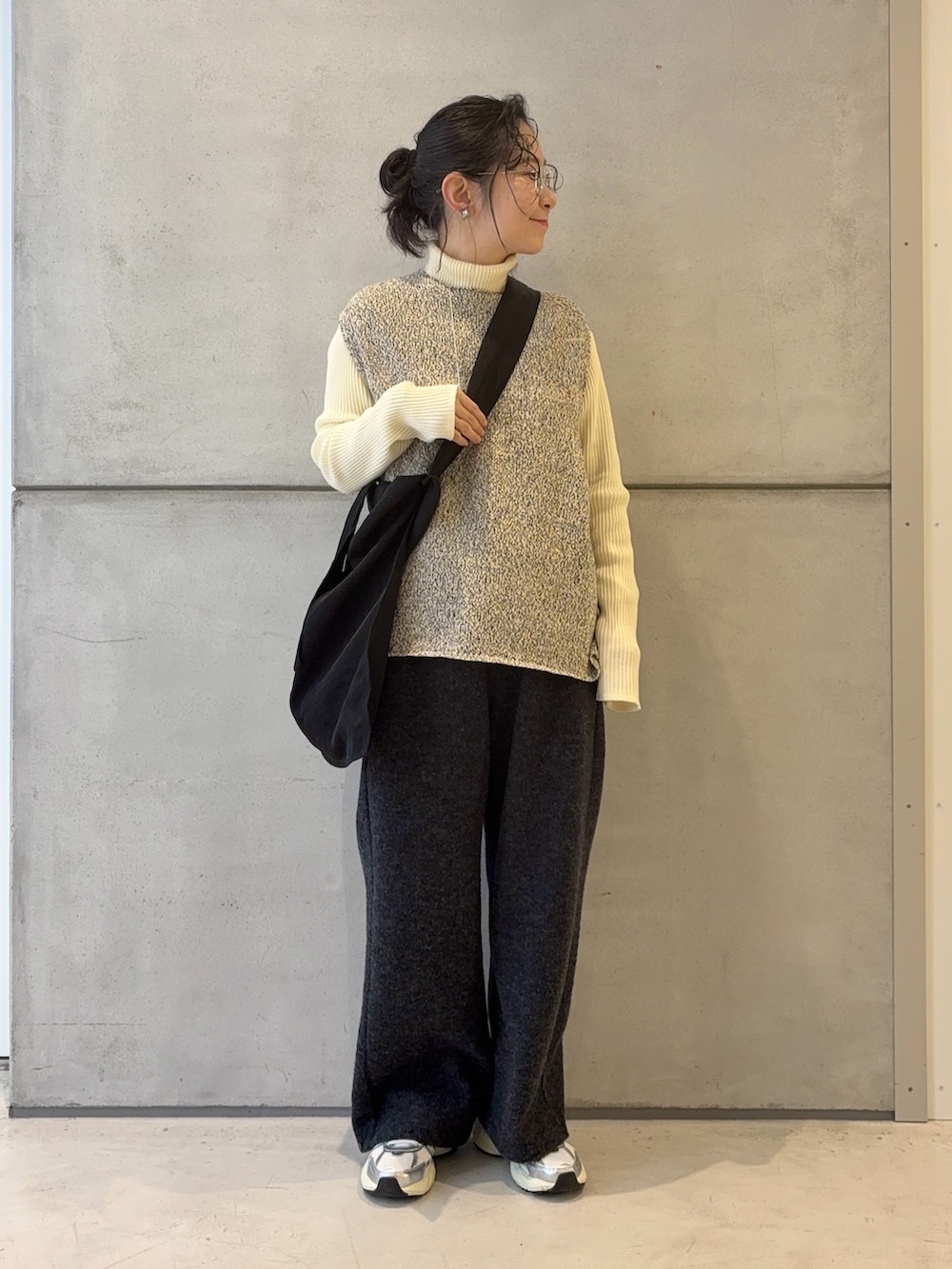 ブラック系のトートバッグ、グレー系のその他パンツ、シルバー系のスニーカーを着用したレディースの冬コーディネートの2枚目の写真