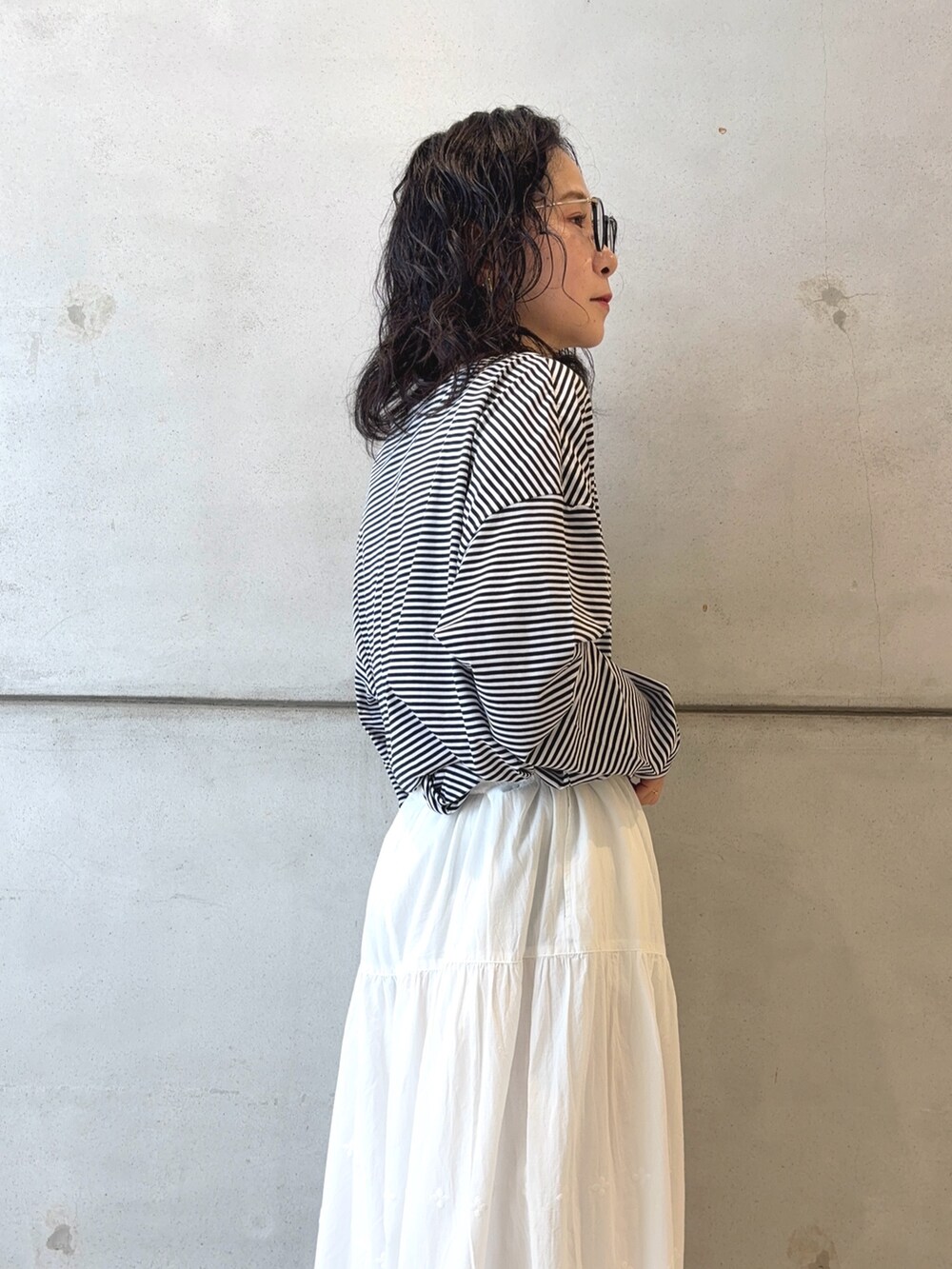 ブラック系のTシャツ/カットソー、ブラック系のその他アウター、ホワイト系のその他パンツを着用したレディースの秋コーディネートの7枚目の写真