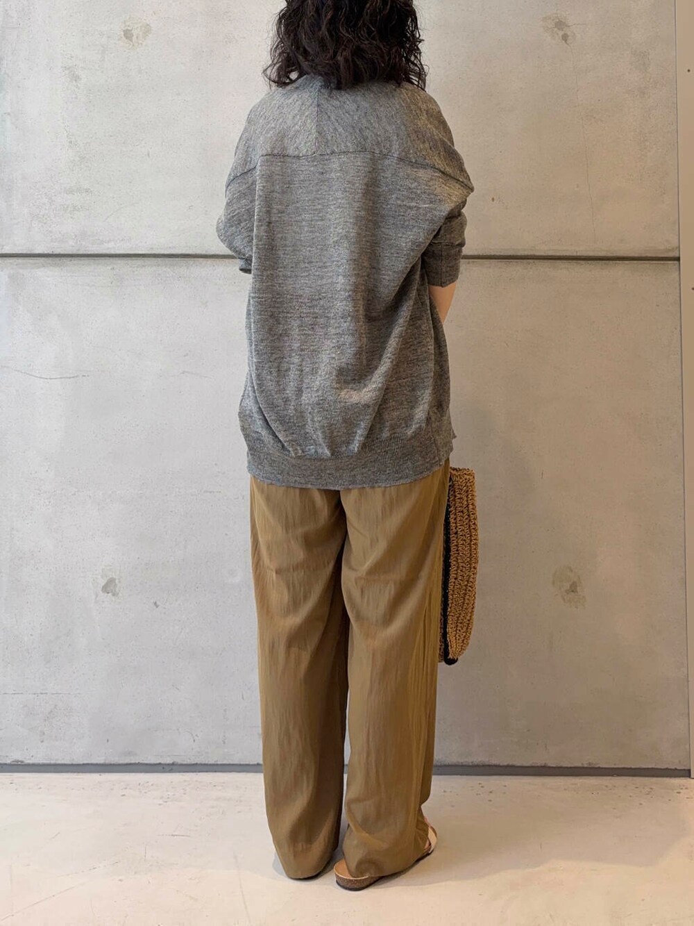 グレー系のカーディガン/ボレロ、ベージュ系のトートバッグ、ホワイト系のタンクトップを着用したレディースの夏コーディネートの5枚目の写真