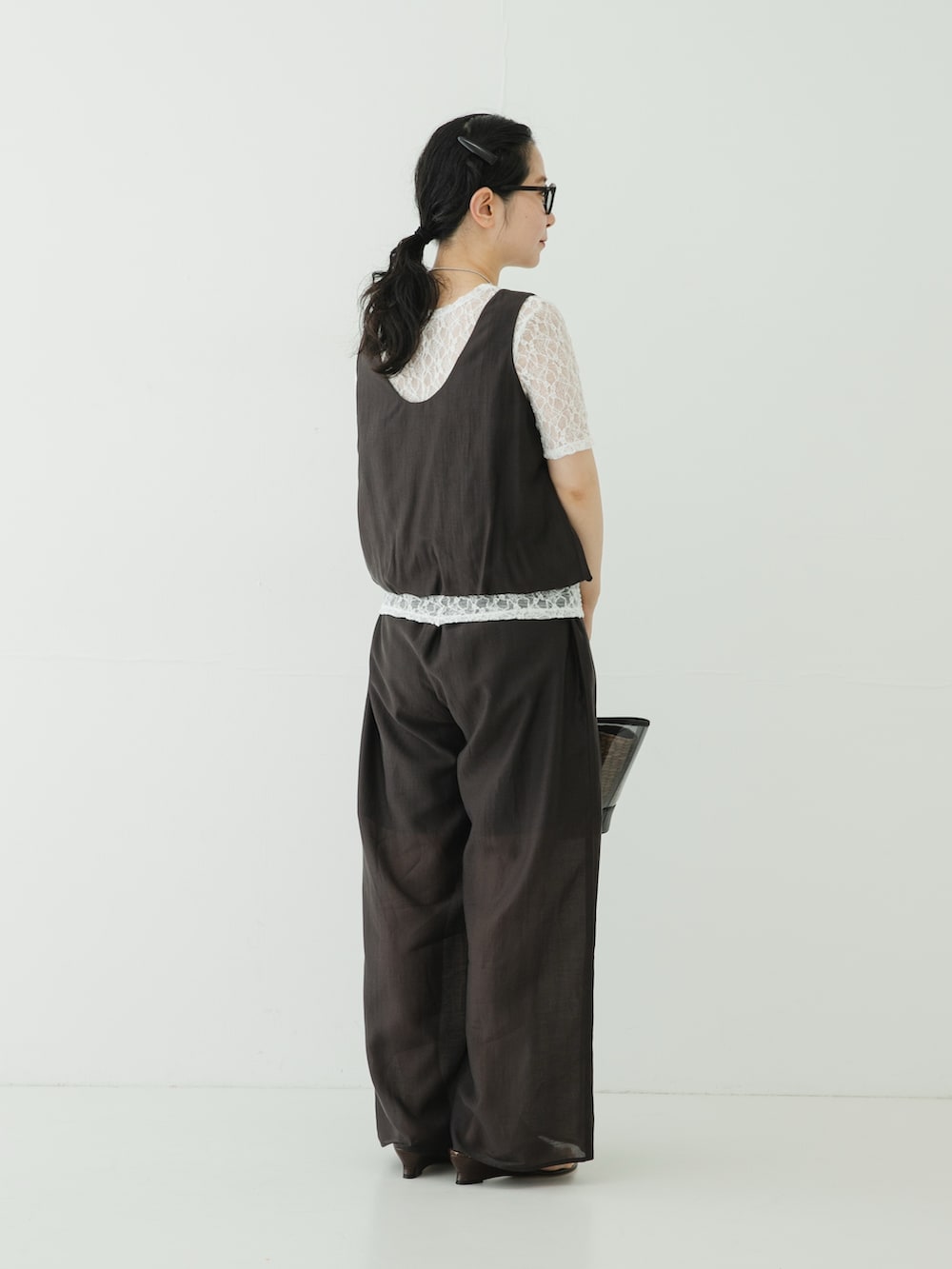グレー系のその他パンツ、ブラウン系のサンダル、ブラック系のかごバッグを着用したレディースの夏コーディネートの4枚目の写真
