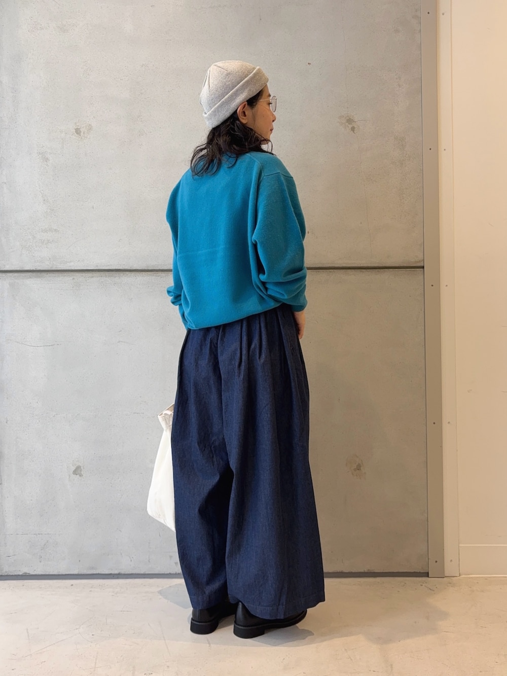 ブルー系のニット/セーター、ブラック系のローファー、ブルー系のデニムパンツを着用したレディースの秋コーディネートの4枚目の写真