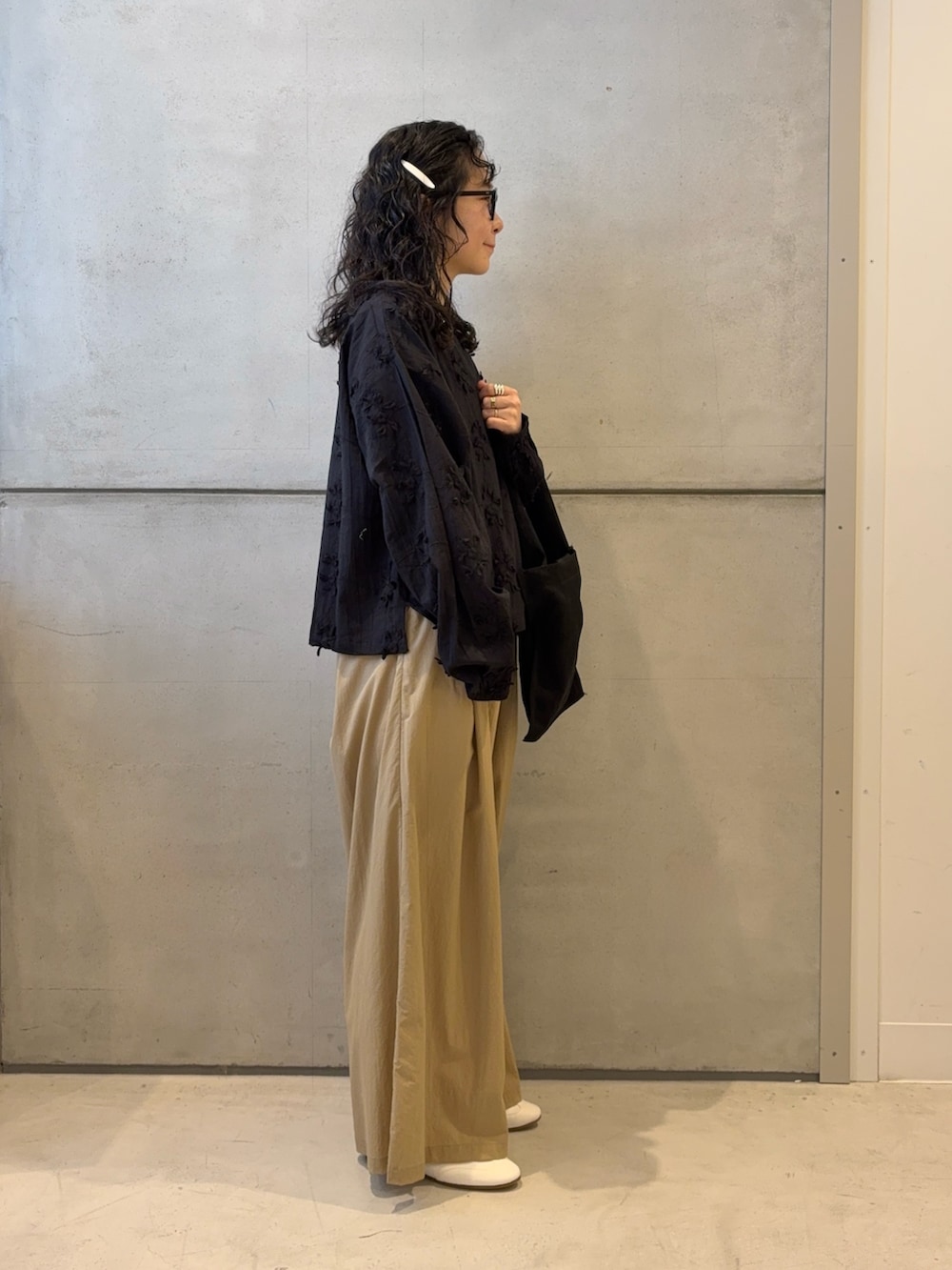 ベージュ系のその他パンツ、ブラック系のトートバッグ、ホワイト系のスニーカーを着用したレディースの春コーディネートの3枚目の写真