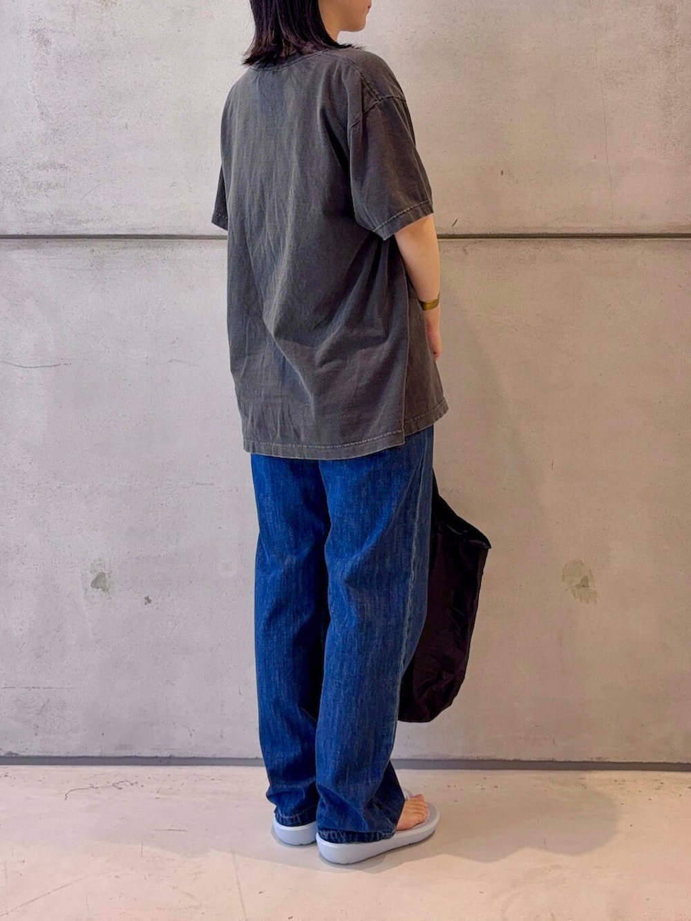 ブルー系のデニムパンツ、グレー系のTシャツ/カットソー、ブラウン系のベルトを着用したレディースの春コーディネートの5枚目の写真