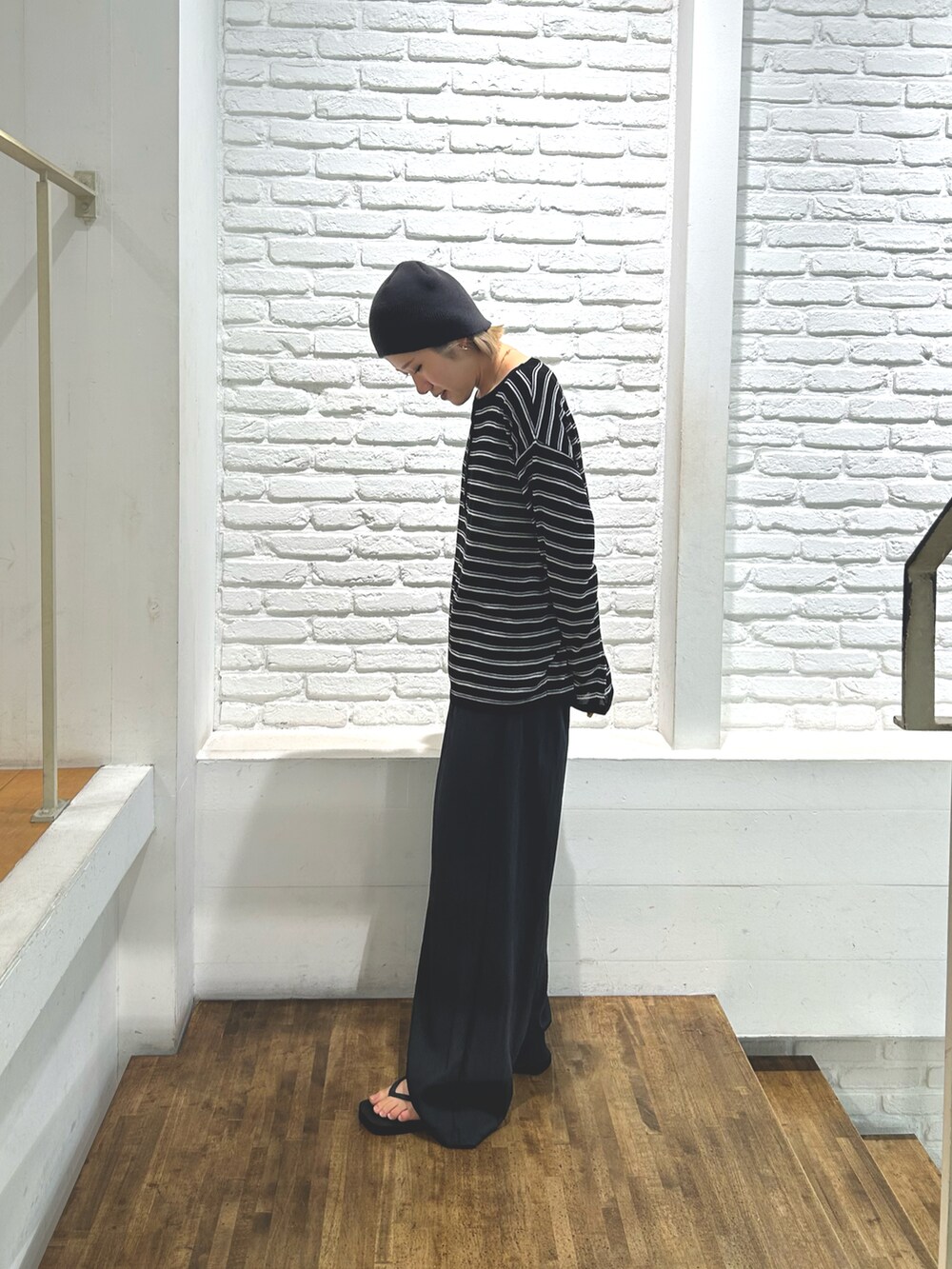 ブラック系のニット/セーター、グレー系のその他パンツ、ブラック系のサンダルを着用したレディースの夏コーディネートの2枚目の写真