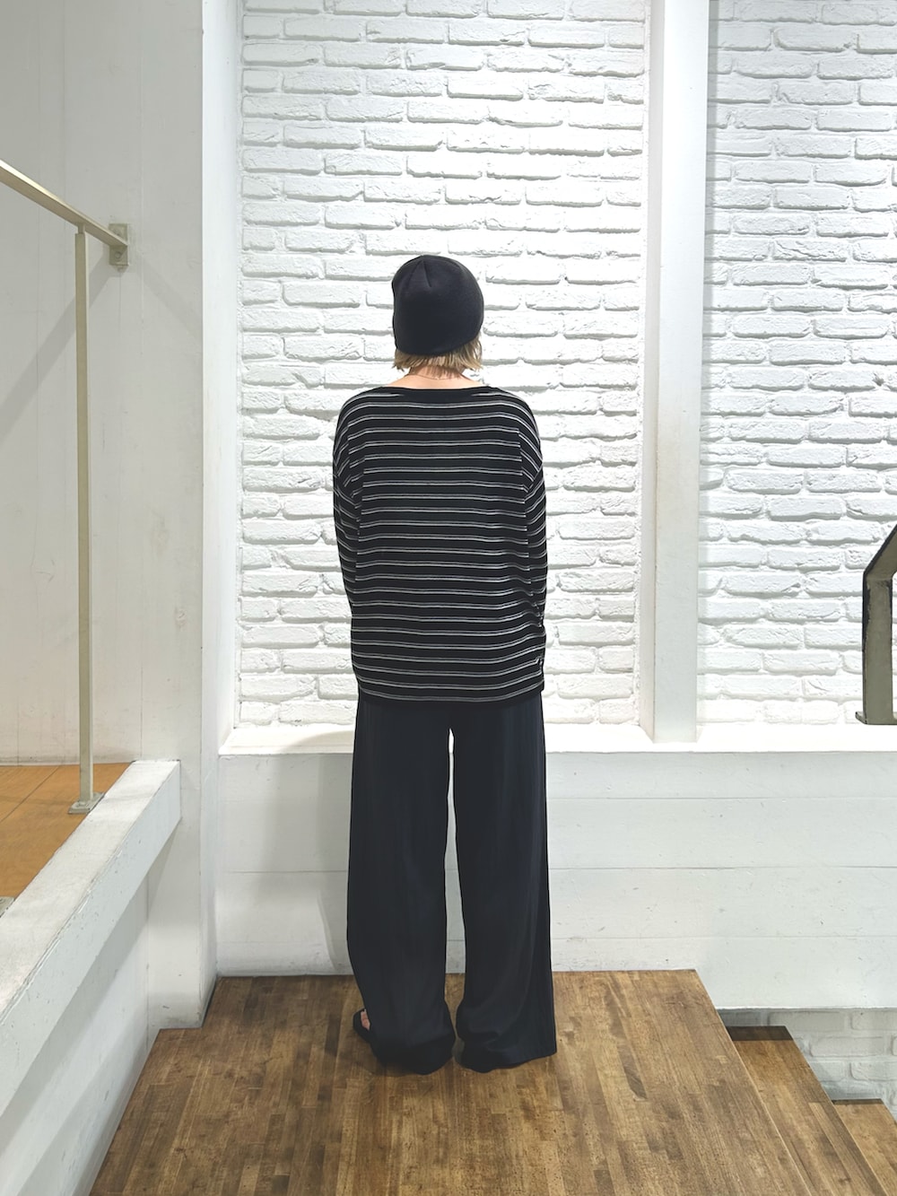 ブラック系のニット/セーター、グレー系のその他パンツ、ブラック系のサンダルを着用したレディースの夏コーディネートの3枚目の写真