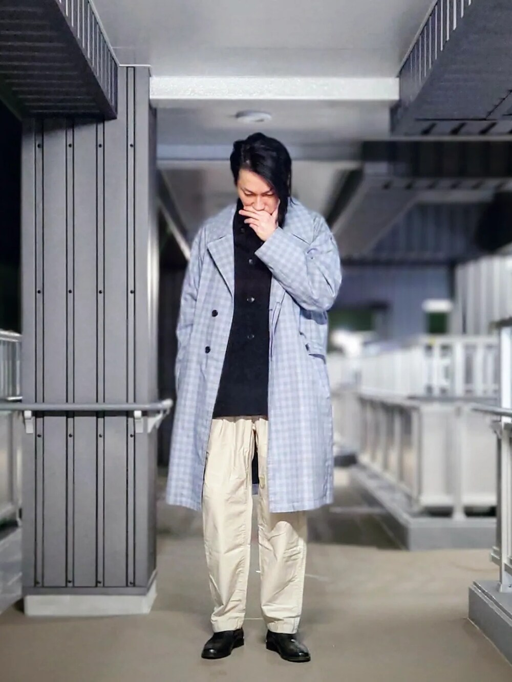 ブルー系のチェスターコート、ブラック系のシャツ/ブラウス、ベージュ系のチノパンツを着用したメンズの春コーディネートの4枚目の写真