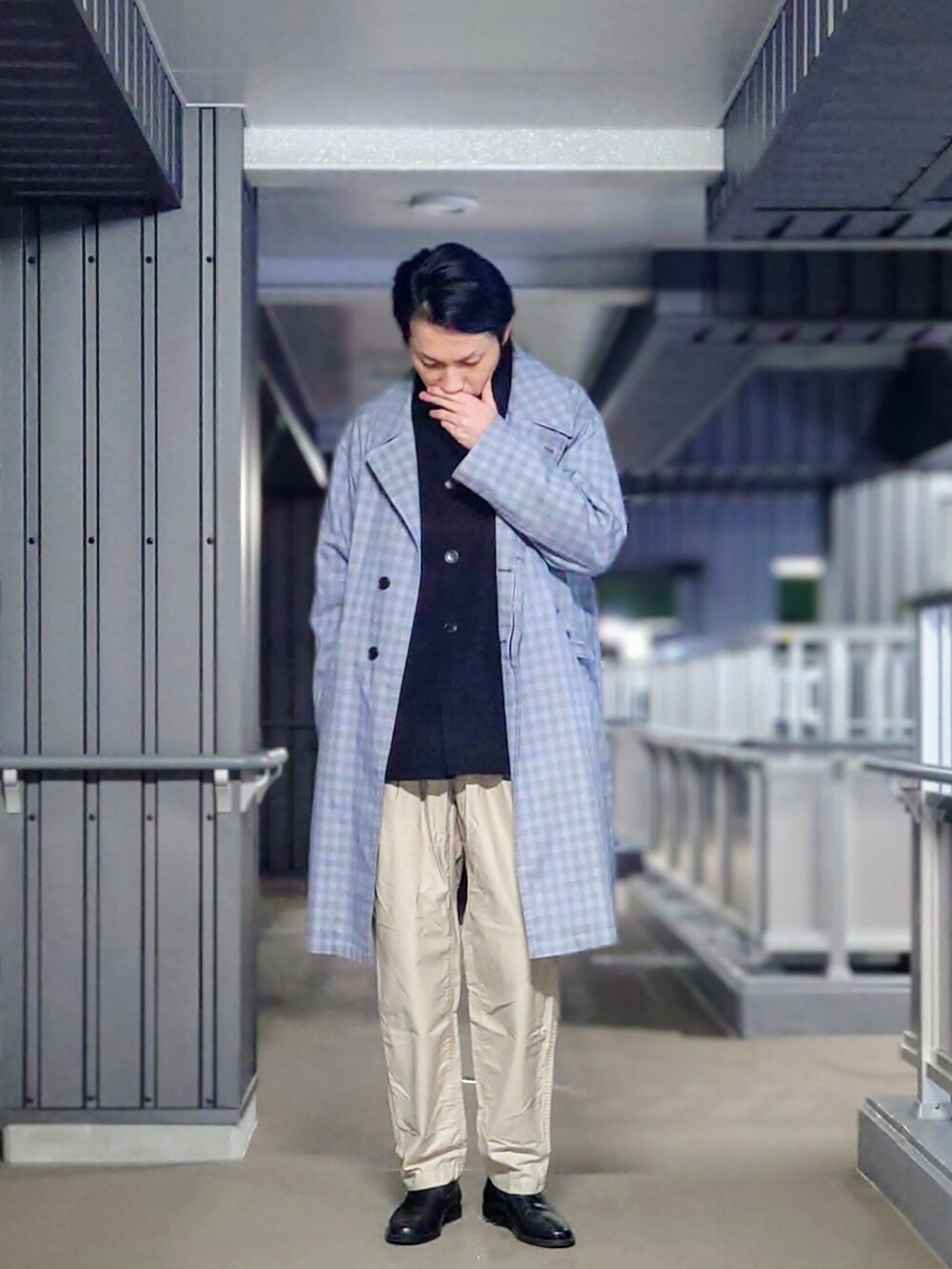 ブルー系のチェスターコート、ブラック系のシャツ/ブラウス、ベージュ系のチノパンツを着用したメンズの春コーディネートの2枚目の写真