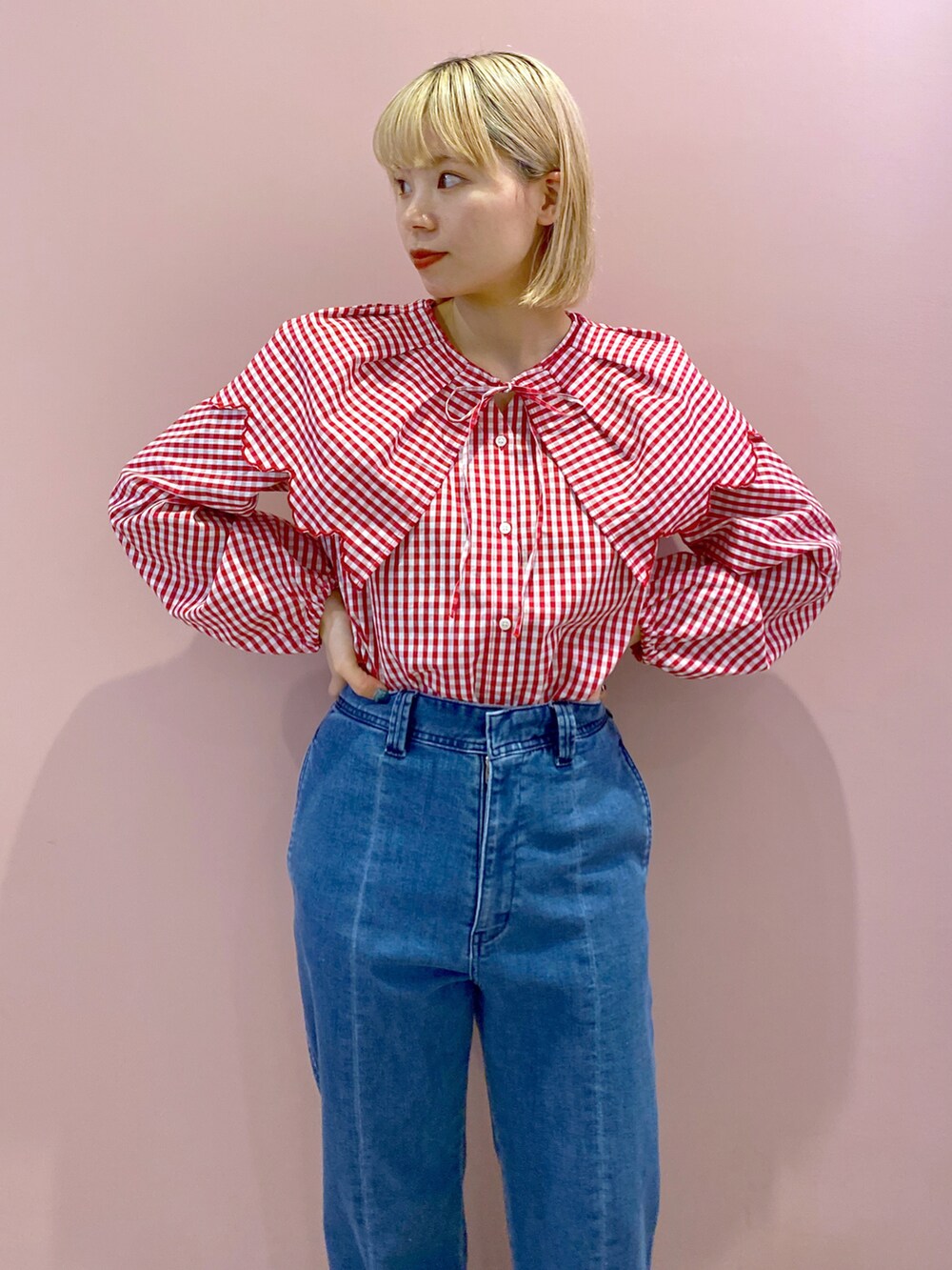 レッド系のシャツ/ブラウス、ブルー系のデニムパンツ、ホワイト系のハンドバッグを着用したレディースの春コーディネートの3枚目の写真