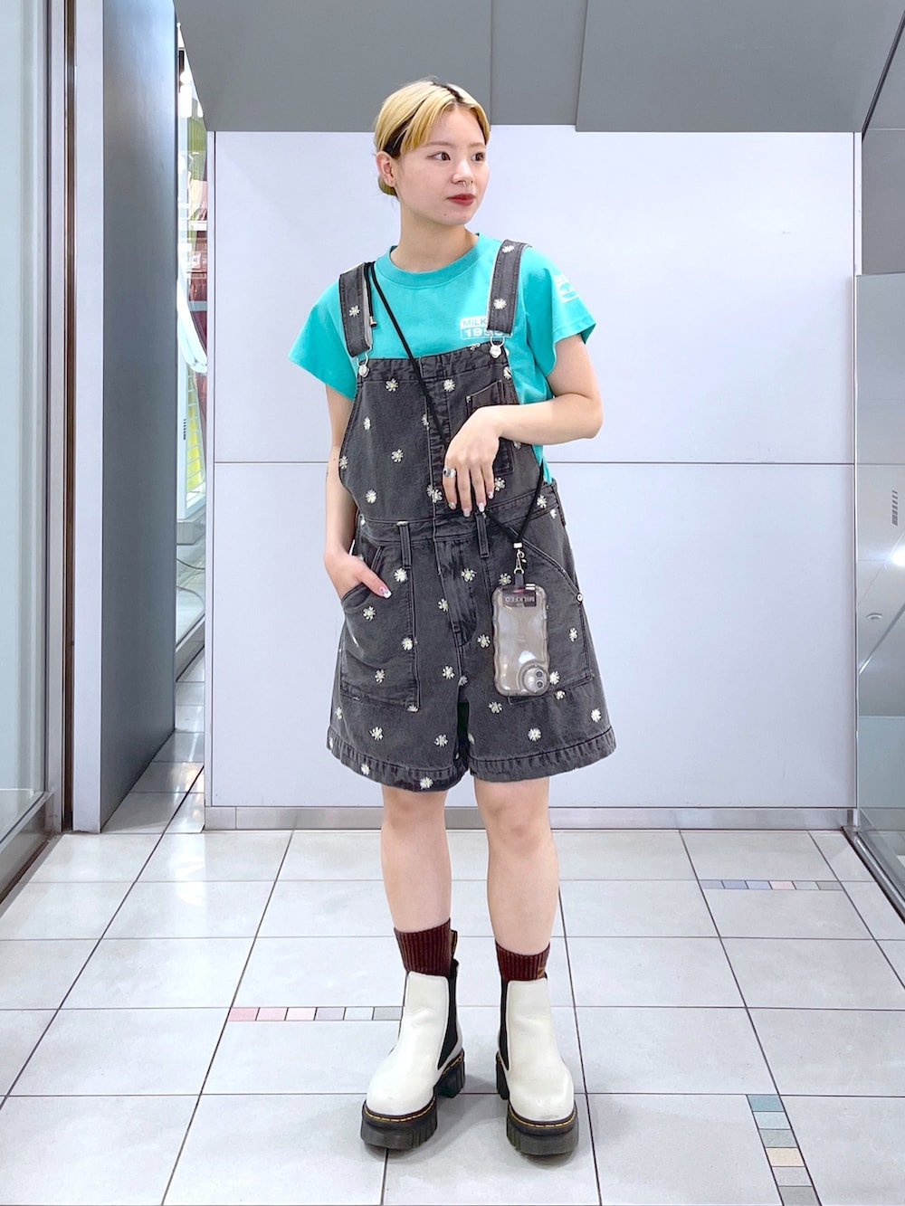 グリーン系のTシャツ/カットソー、ブラック系のサロペット/オーバーオール、ブラック系のスマホグッズを着用したレディースの夏コーディネートの2枚目の写真