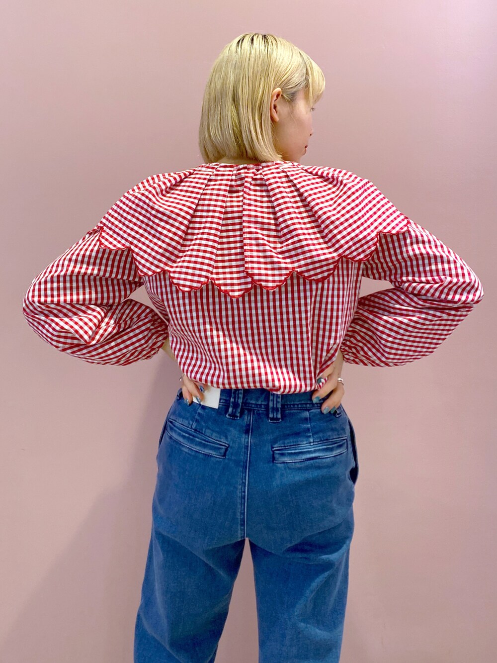 レッド系のシャツ/ブラウス、ブルー系のデニムパンツ、ホワイト系のハンドバッグを着用したレディースの春コーディネートの4枚目の写真
