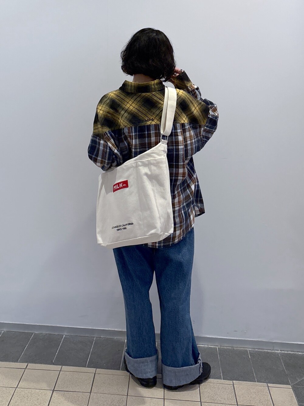 イエロー系のシャツ/ブラウス、ブルー系のデニムパンツ、その他のトートバッグを着用したレディースの冬コーディネートの4枚目の写真