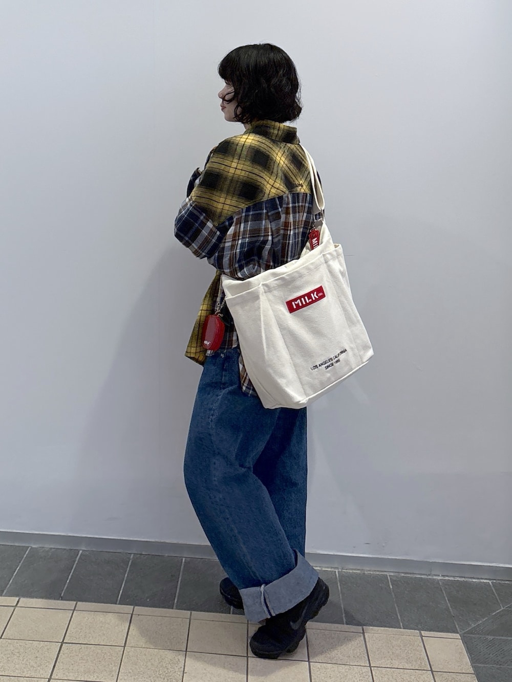 イエロー系のシャツ/ブラウス、ブルー系のデニムパンツ、その他のトートバッグを着用したレディースの冬コーディネートの3枚目の写真