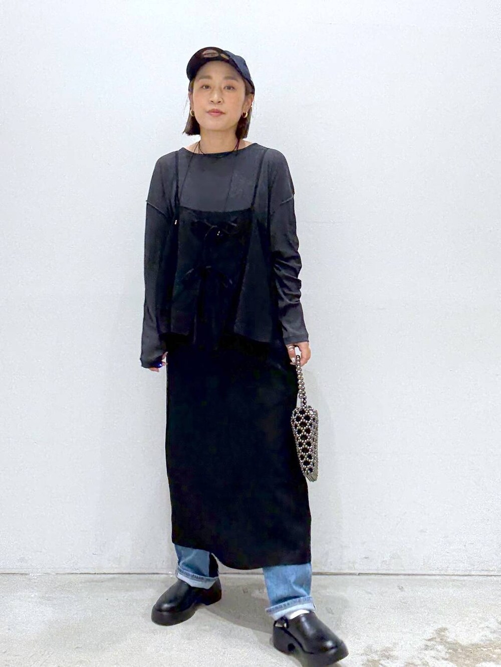 ブラック系のショルダーバッグ、ブルー系のデニムパンツ、ブラック系のサンダルを着用したレディースの夏コーディネートの7枚目の写真