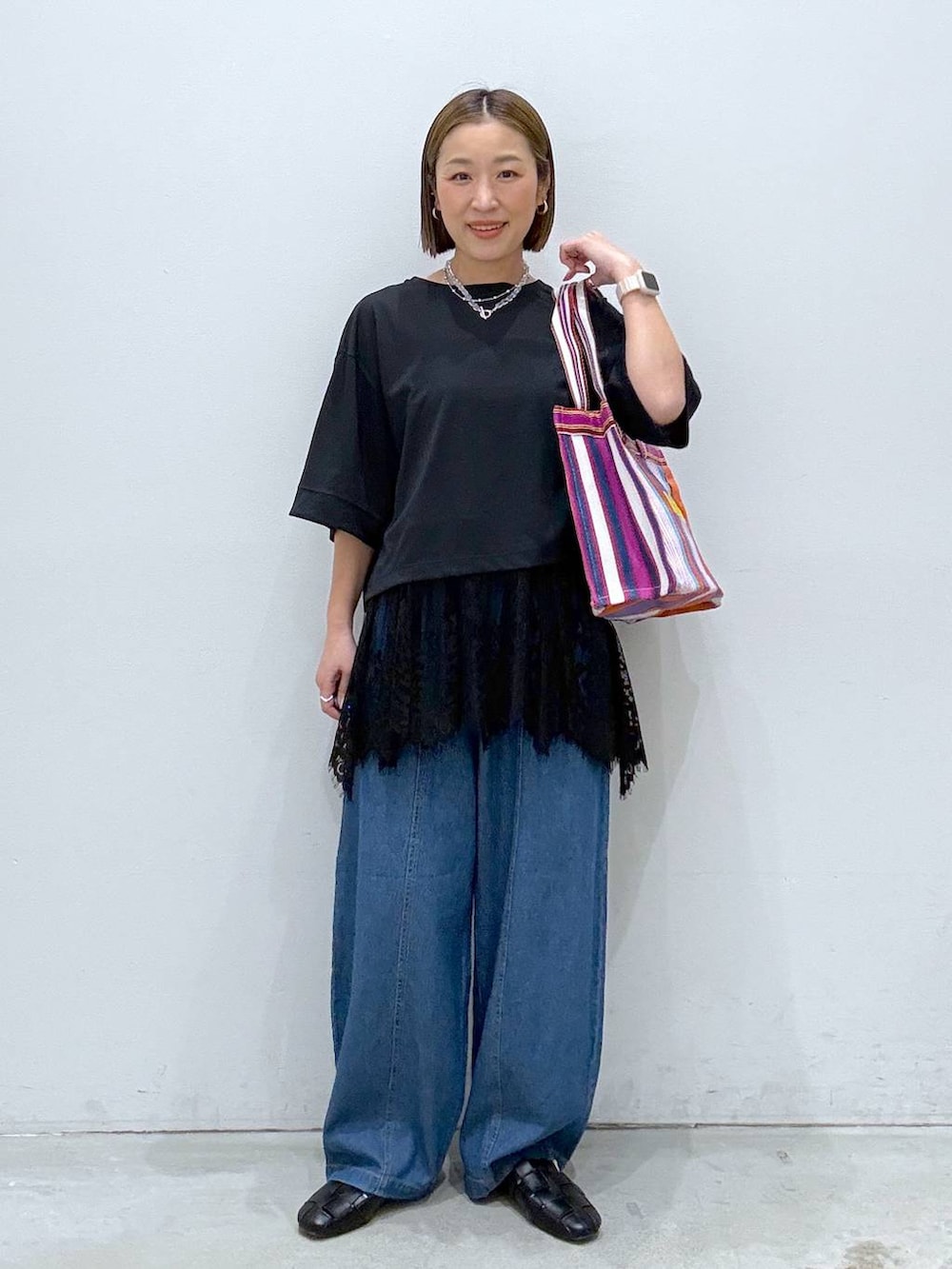 ブラック系のTシャツ/カットソー、ブラック系のパンプス、ブルー系のデニムパンツを着用したレディースの春コーディネートの6枚目の写真