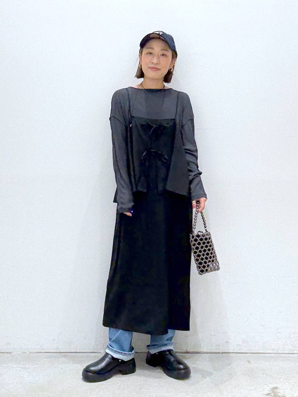 ブラック系のショルダーバッグ、ブルー系のデニムパンツ、ブラック系のサンダルを着用したレディースの夏コーディネートの2枚目の写真