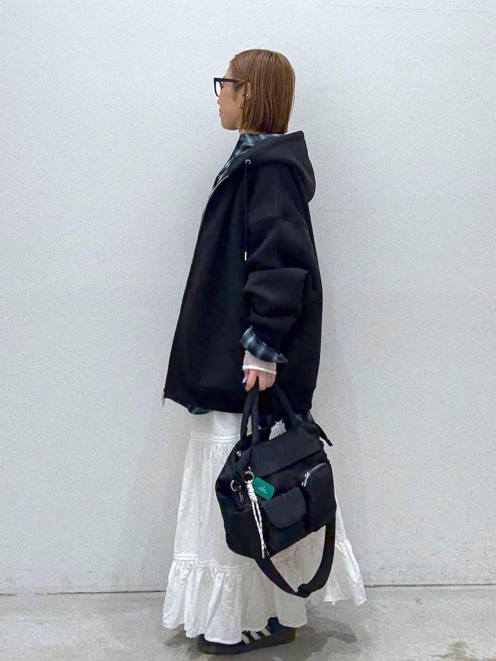 ブラック系のパーカー、ホワイト系のTシャツ/カットソー、ブラック系のトートバッグを着用したレディースの冬コーディネートの3枚目の写真