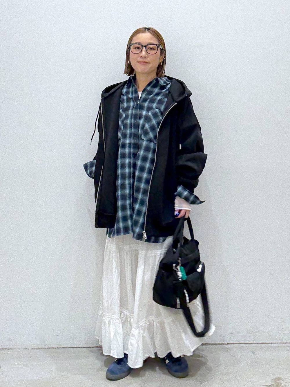 ブラック系のパーカー、ホワイト系のTシャツ/カットソー、ブラック系のトートバッグを着用したレディースの冬コーディネートの2枚目の写真