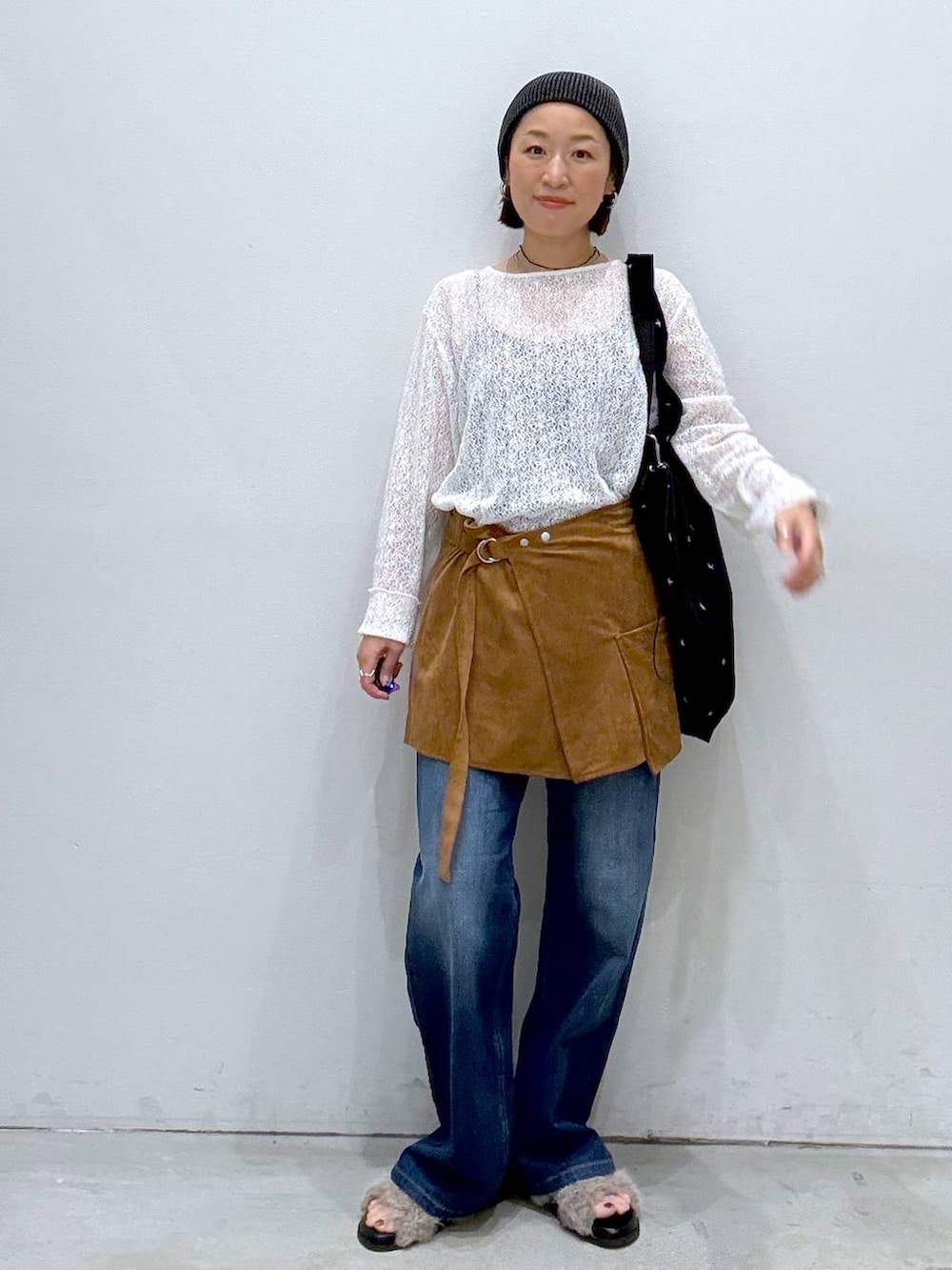 ブラウン系のサンダル、ブラック系のトートバッグ、ブルー系のデニムパンツを着用したレディースの夏コーディネートの2枚目の写真