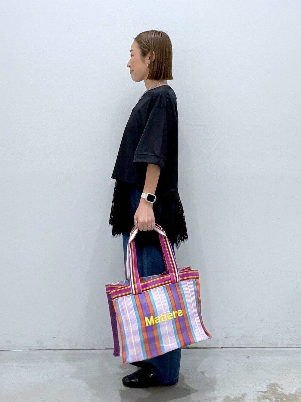 ブラック系のTシャツ/カットソー、ブラック系のパンプス、ブルー系のデニムパンツを着用したレディースの春コーディネートの3枚目の写真