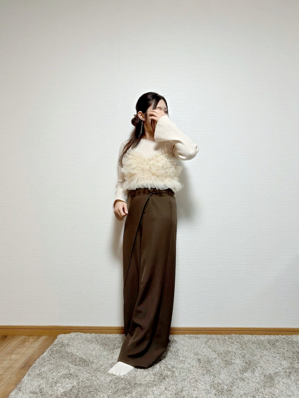 ベージュ系のキャミソール、ホワイト系のニット/セーター、ブラウン系のパンツを着用したレディースの春コーディネートの3枚目の写真