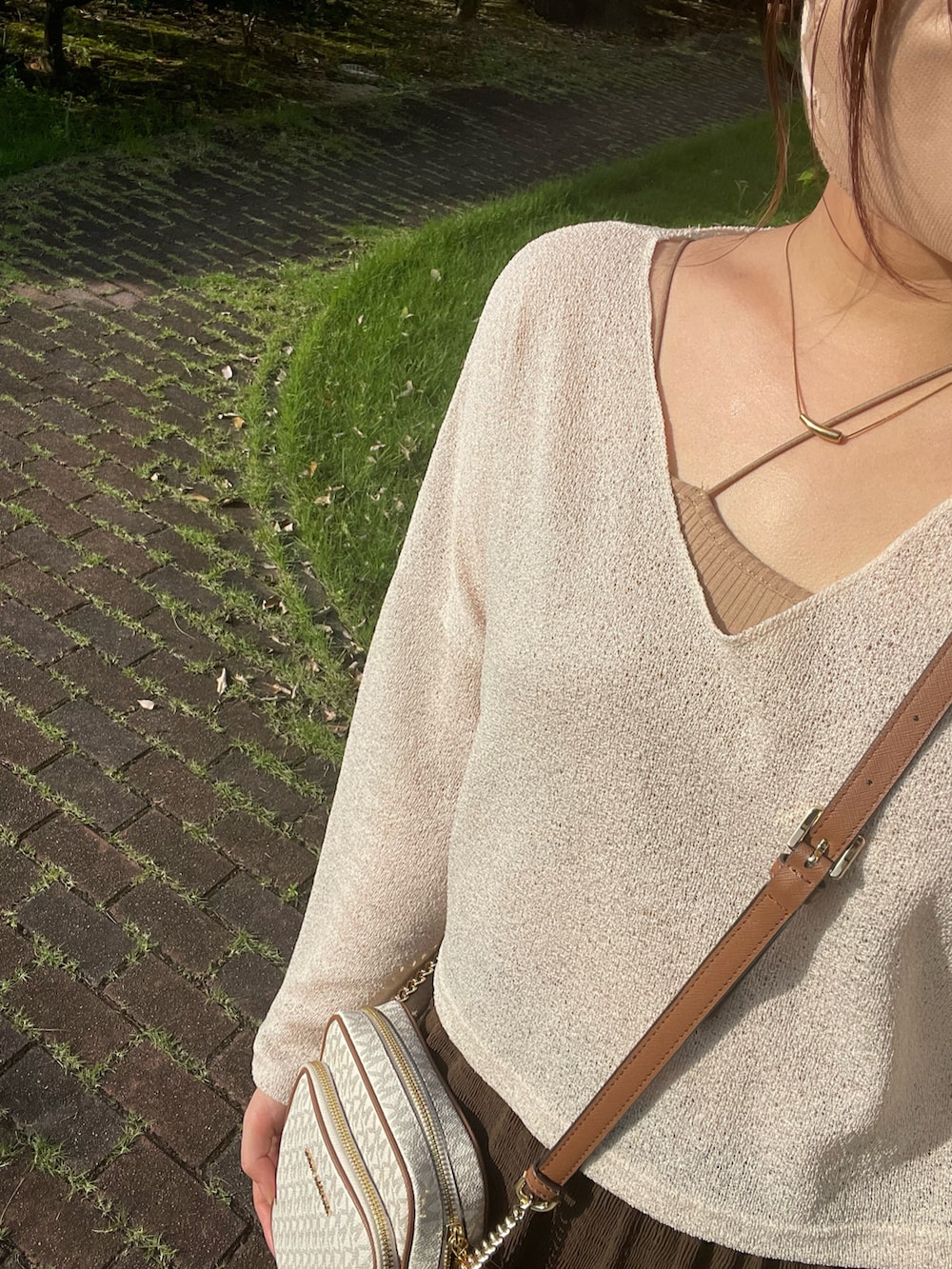 ブラウン系のスカート、ベージュ系のトップス、ブラウン系のキャミソールを着用したレディースの夏コーディネートの4枚目の写真