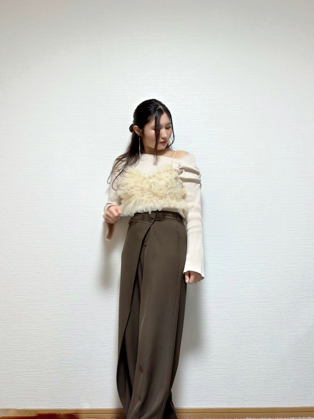 ベージュ系のキャミソール、ホワイト系のニット/セーター、ブラウン系のパンツを着用したレディースの春コーディネートの4枚目の写真