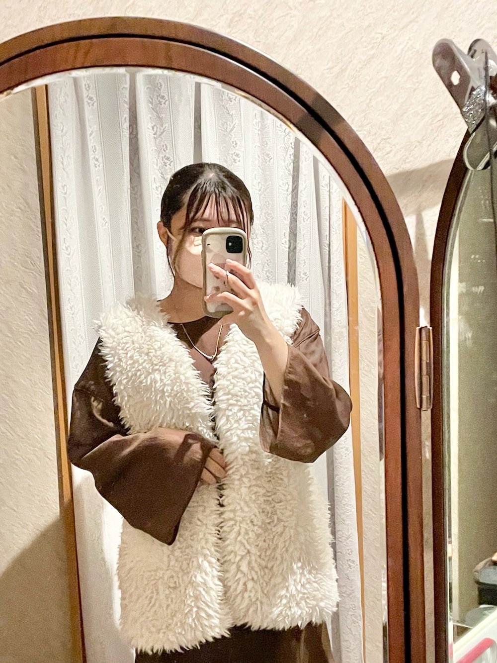 ブラウン系のワンピース、ホワイト系のベスト、ブラック系のキャミソールを着用したレディースの秋コーディネートの2枚目の写真