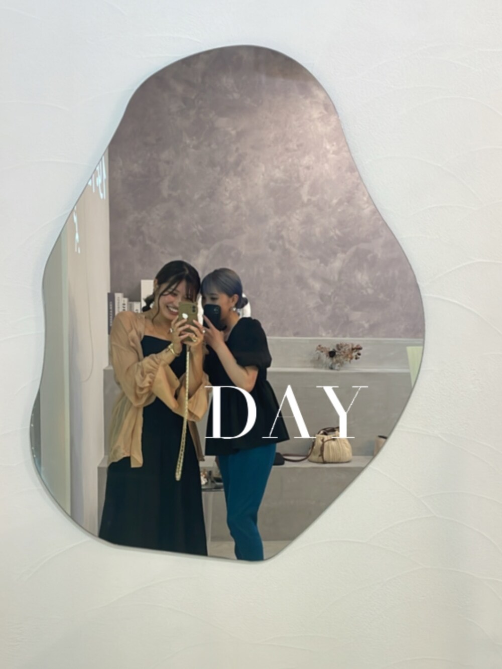 オレンジ系のシャツ/ブラウス、ブラック系のワンピース、ゴールド系のネックレスを着用したレディースの秋コーディネートの2枚目の写真