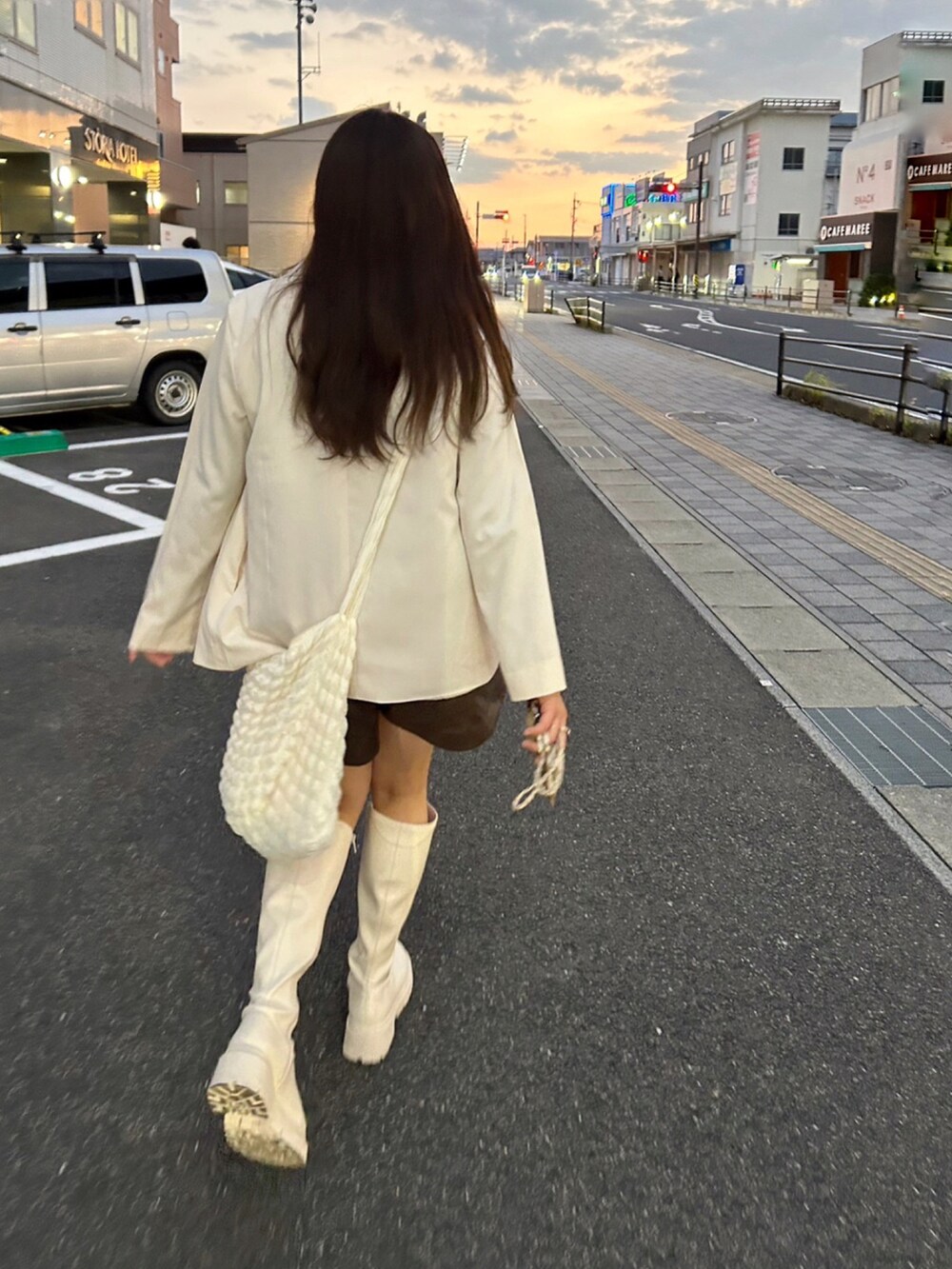 ホワイト系のセットアップ、ブラウン系のTシャツ/カットソー、ホワイト系のブーツを着用したレディースの秋コーディネートの5枚目の写真