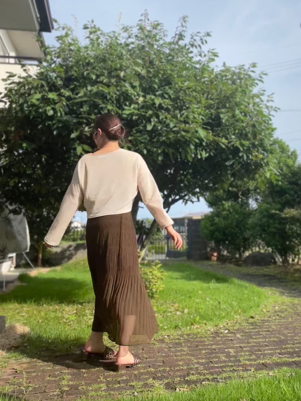 ブラウン系のスカート、ベージュ系のトップス、ブラウン系のキャミソールを着用したレディースの夏コーディネートの3枚目の写真