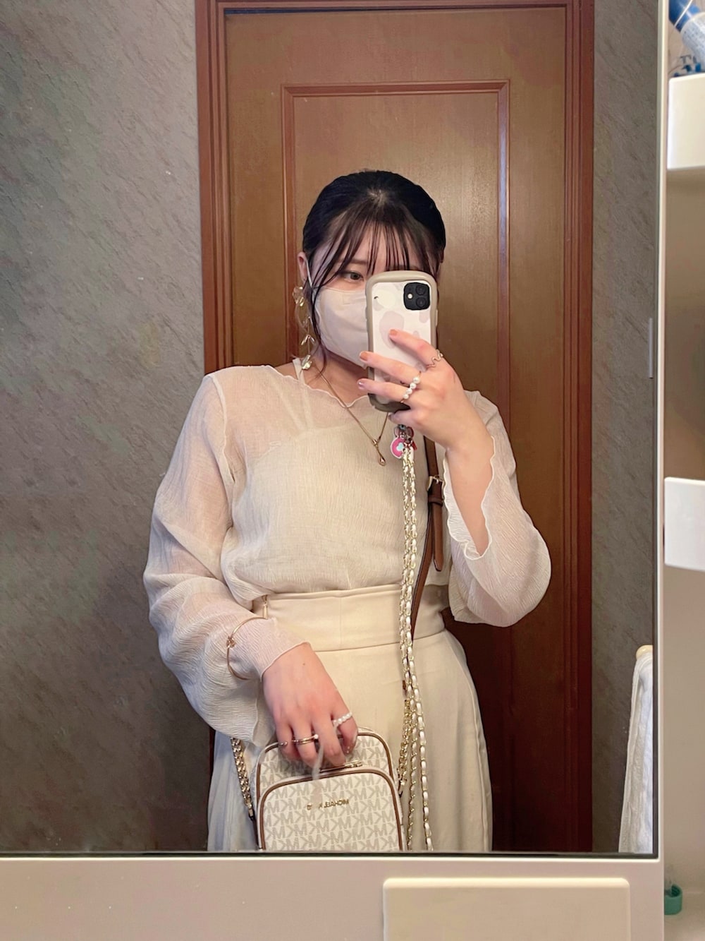 ホワイト系のシャツ/ブラウス、ホワイト系のスカート、ベージュ系のタンクトップを着用したレディースの春コーディネートの4枚目の写真