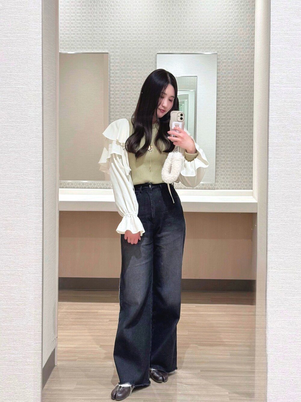 ホワイト系のカーディガン/ボレロ、ブラック系のデニムパンツ、グリーン系のニット/セーターを着用したレディースの春コーディネートの2枚目の写真