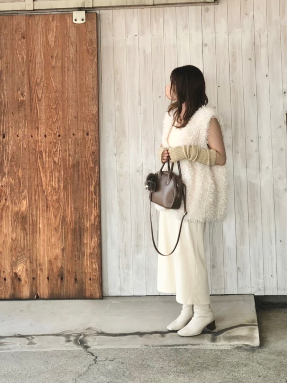 ホワイト系のワンピース、ベージュ系のショルダーバッグ、ホワイト系のブーツを着用したレディースの秋コーディネートの3枚目の写真