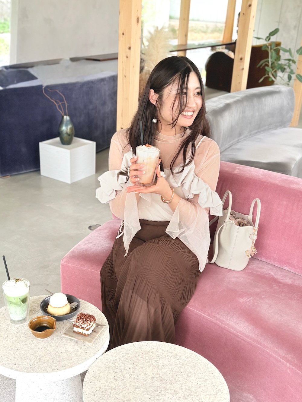 ブラウン系のスカート、ホワイト系のTシャツ/カットソー、ベージュ系のワンピースを着用したレディースの夏コーディネートの2枚目の写真