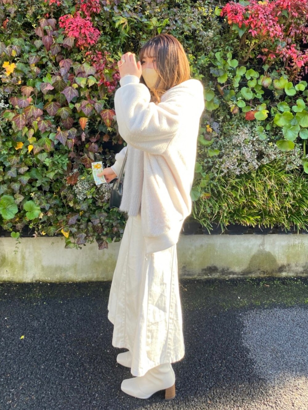 ホワイト系のその他アウター、ホワイト系のブーツ、ベージュ系のデニムスカートを着用したレディースの冬コーディネートの2枚目の写真