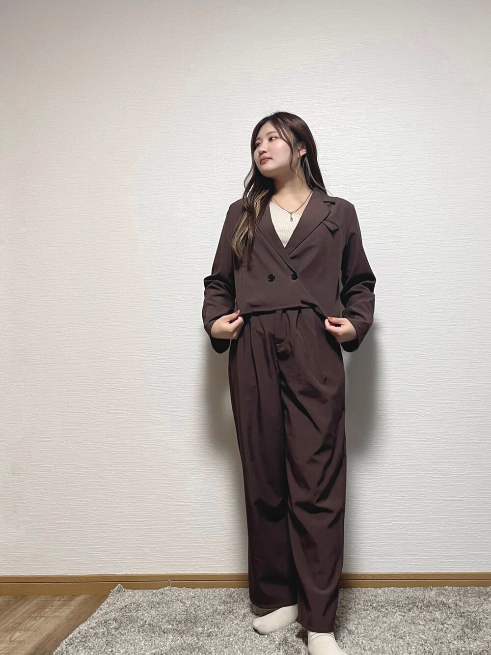 ブラウン系のテーラードジャケット、ベージュ系のタンクトップ、ゴールド系のネックレスを着用したレディースの秋コーディネートの3枚目の写真