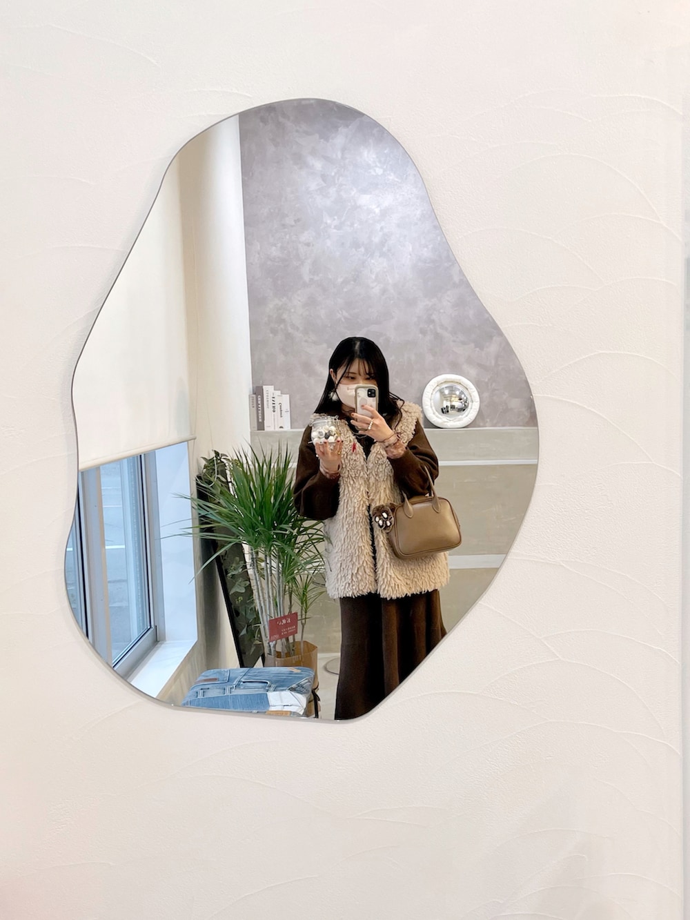 ブラウン系のワンピース、ベージュ系のベスト、ベージュ系のショルダーバッグを着用したレディースの冬コーディネートの2枚目の写真