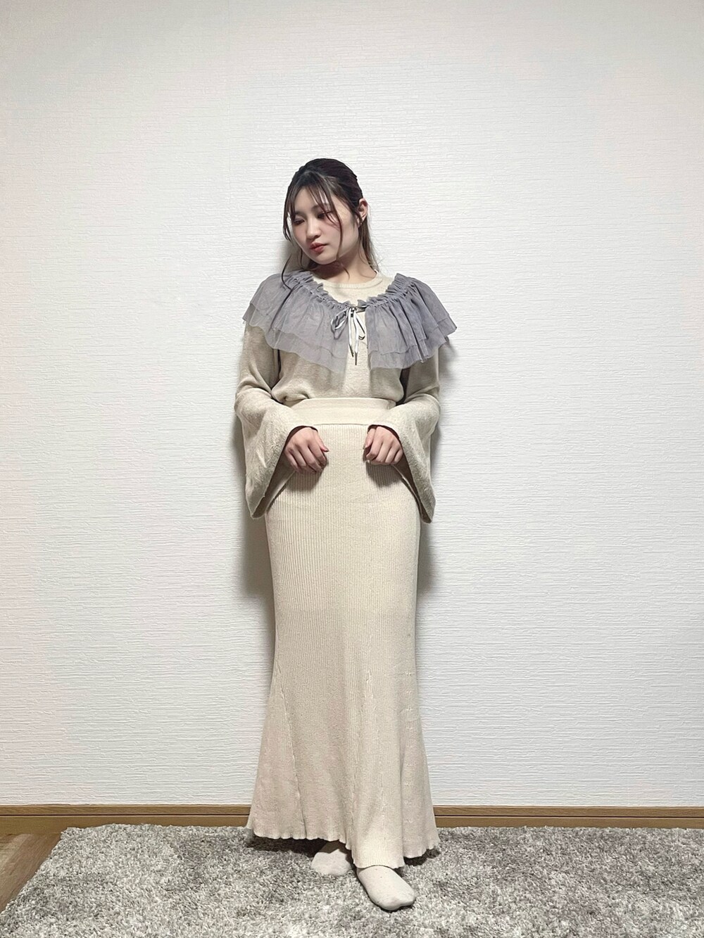 ホワイト系のニット/セーター、ベージュ系のスカート、グレー系のシャツ/ブラウスを着用したレディースの春コーディネートの3枚目の写真