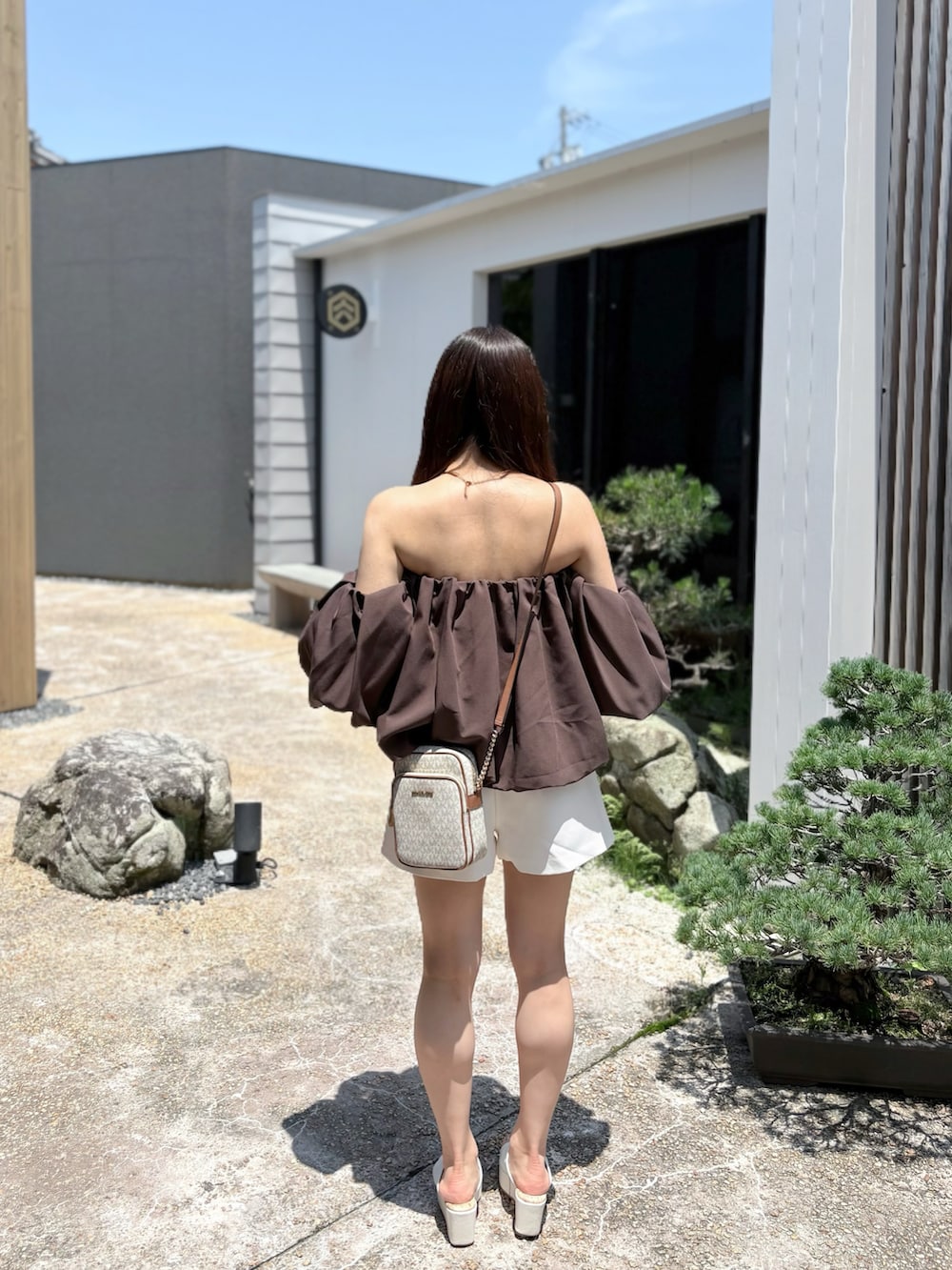 ブラウン系のシャツ/ブラウス、ホワイト系のパンツを着用したレディースの夏コーディネートの3枚目の写真