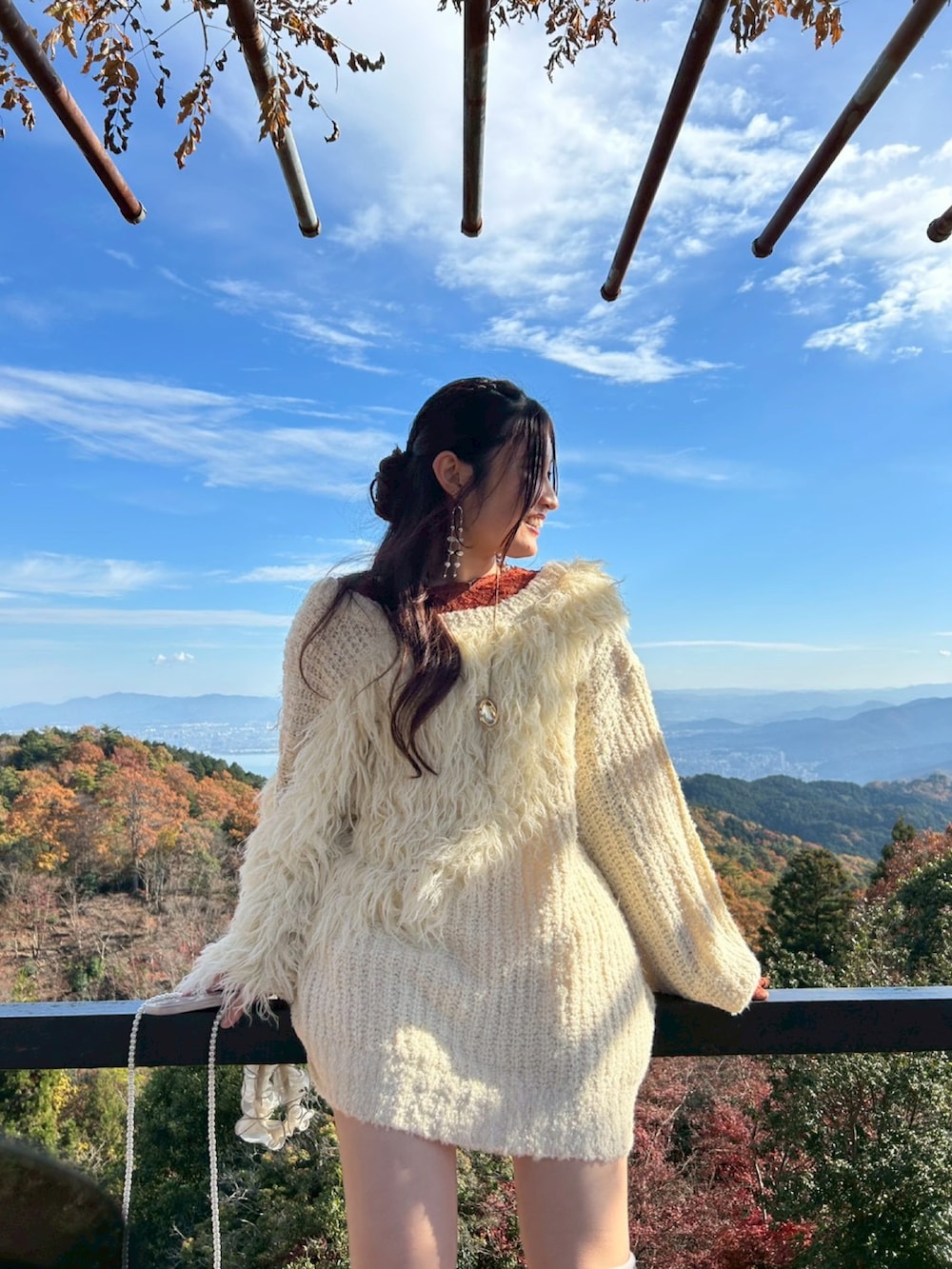 ベージュ系のニット/セーター、オレンジ系のTシャツ/カットソー、ブラック系のブーツを着用したレディースの秋コーディネートの4枚目の写真