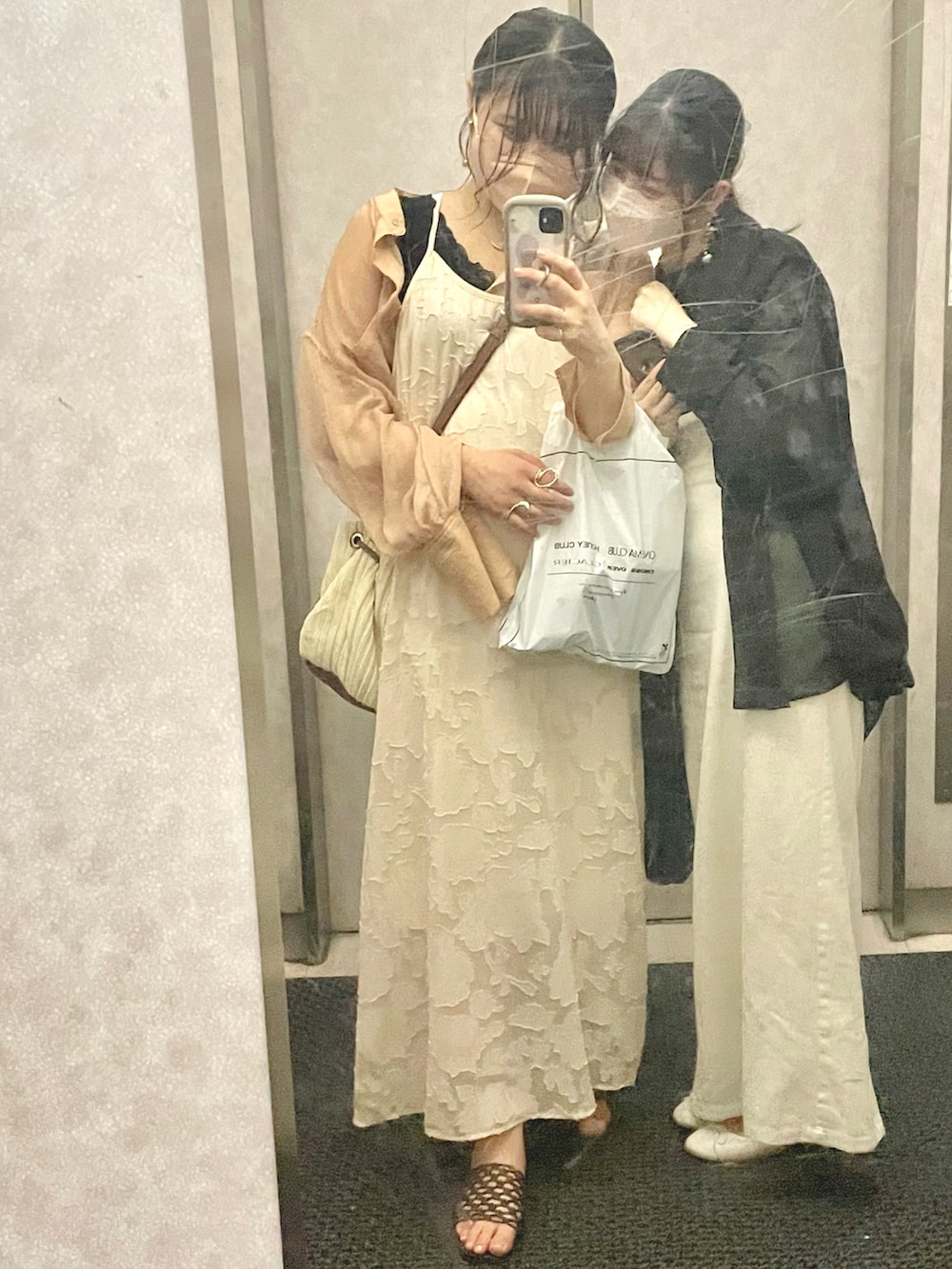 オレンジ系のシャツ/ブラウス、ベージュ系のワンピース、ホワイト系のワンピースを着用したレディースの夏コーディネートの2枚目の写真