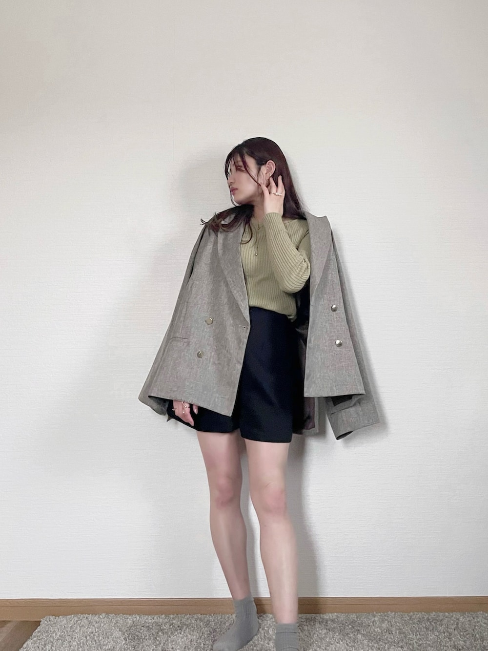 ベージュ系のテーラードジャケット、グリーン系のニット/セーター、ブラック系のその他パンツを着用したレディースの春コーディネートの2枚目の写真